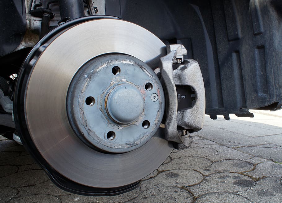 Image close up of rotors and pads with the wheel off the car. 