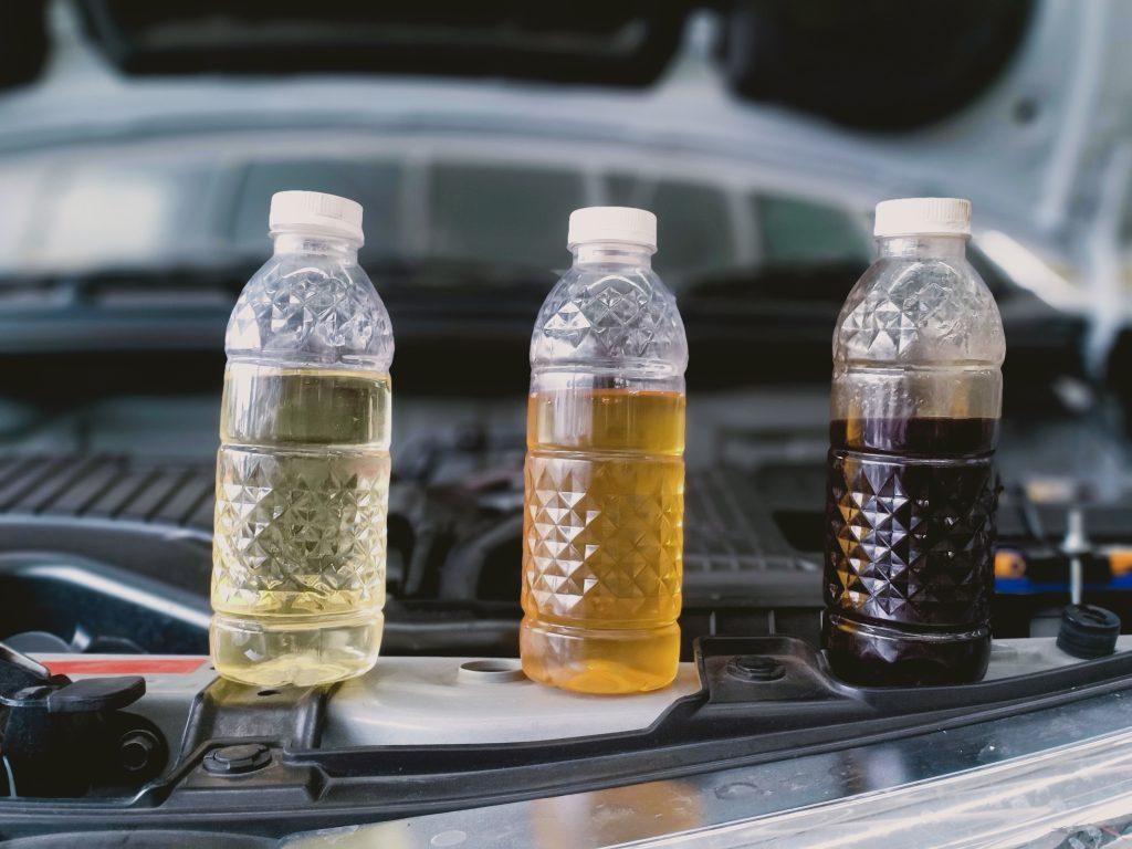 Image of 3 water bottles filled with brake fluid, from clean to okay to dirty