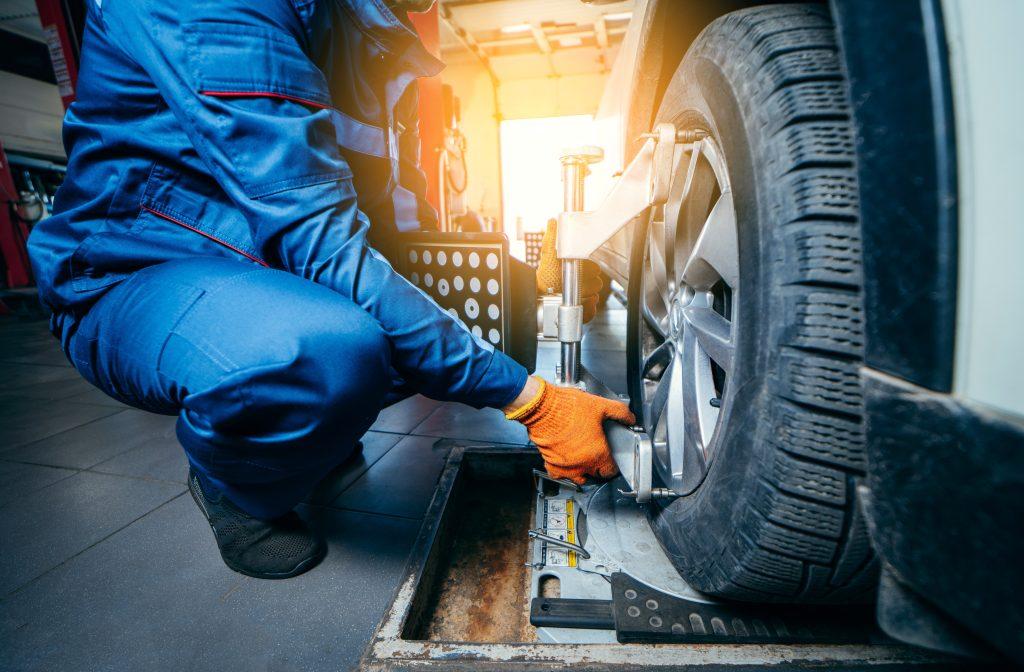 Mechanic putting alignment sensors on a vehicle for service. 