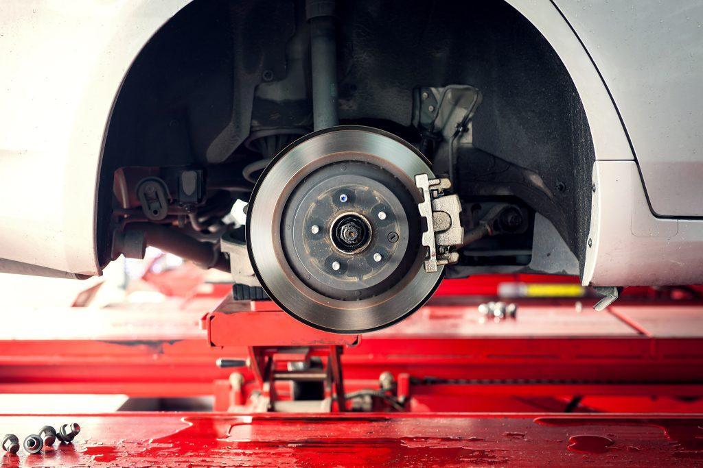 Picture of a wheel off a car and the rotors and pads are shown 