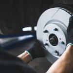 Image of mechanic hands changing out rotors on a vehicle