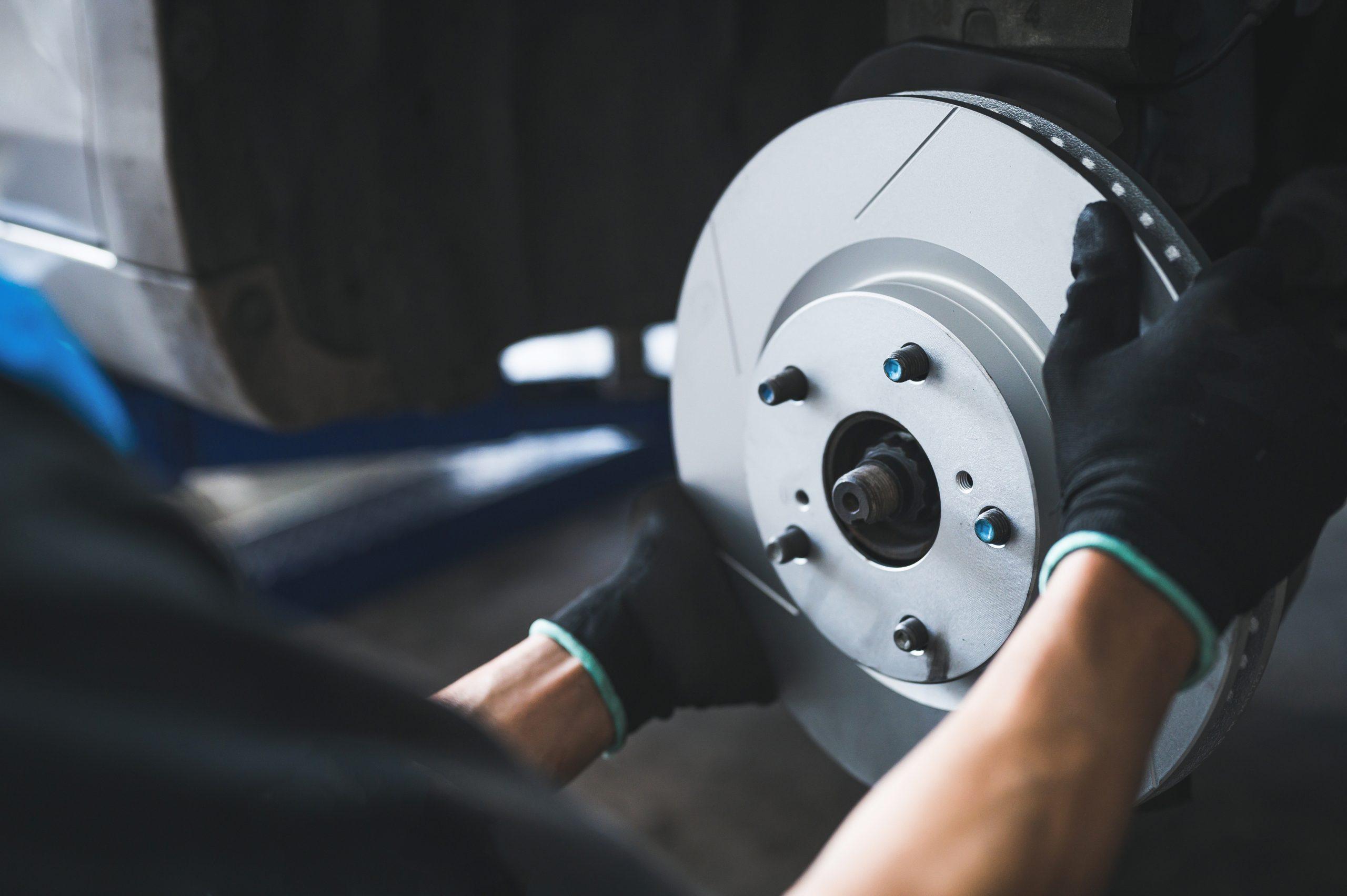 Image of mechanic hands changing out rotors on a vehicle