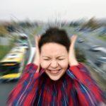 Image of a women covering her ears because of the street traffic