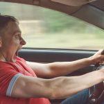 Image of a man driving a car stomping on the brakes