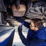 Image of a mechanic inspecting rear brakes.