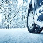 Image of a close up to the front driver tire in the snow